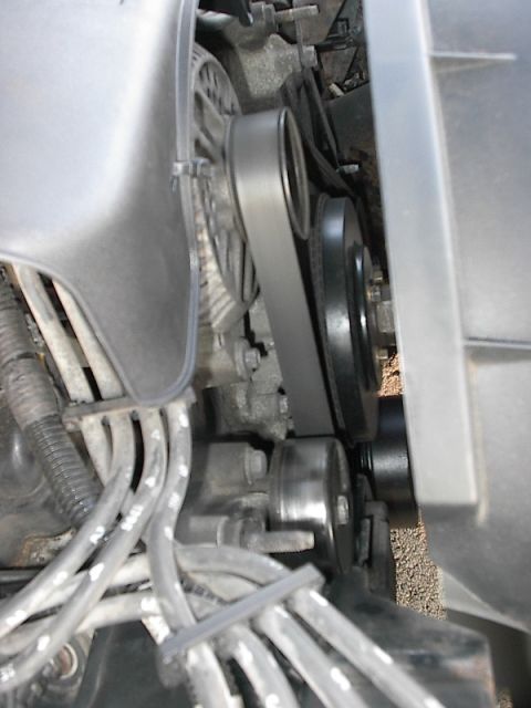 1985 Mercury Grand Marquis - Close-up view of an engine's belt and pulley system, with visible spark plug wires.