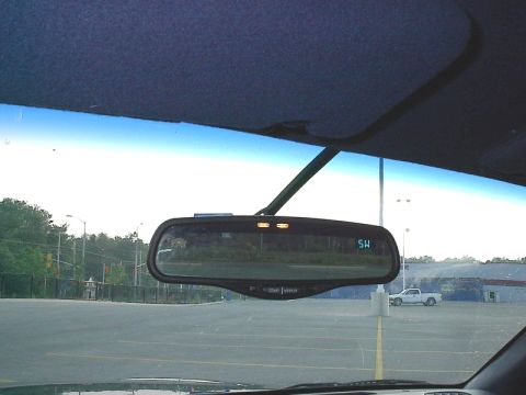 1985 Mercury Grand Marquis - View from inside a vehicle shows the interior rearview mirror with a digital display and a white pickup truck in the background.
