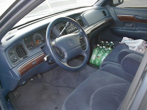 1985 Mercury Grand Marquis - Interior of a 1995 Mercury Grand Marquis, a dashboard, steering wheel, and front seats with soda bottles.