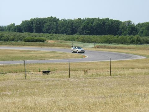 1998 Ford Taurus - A silver sedan navigates a turn on a race track on a clear day.