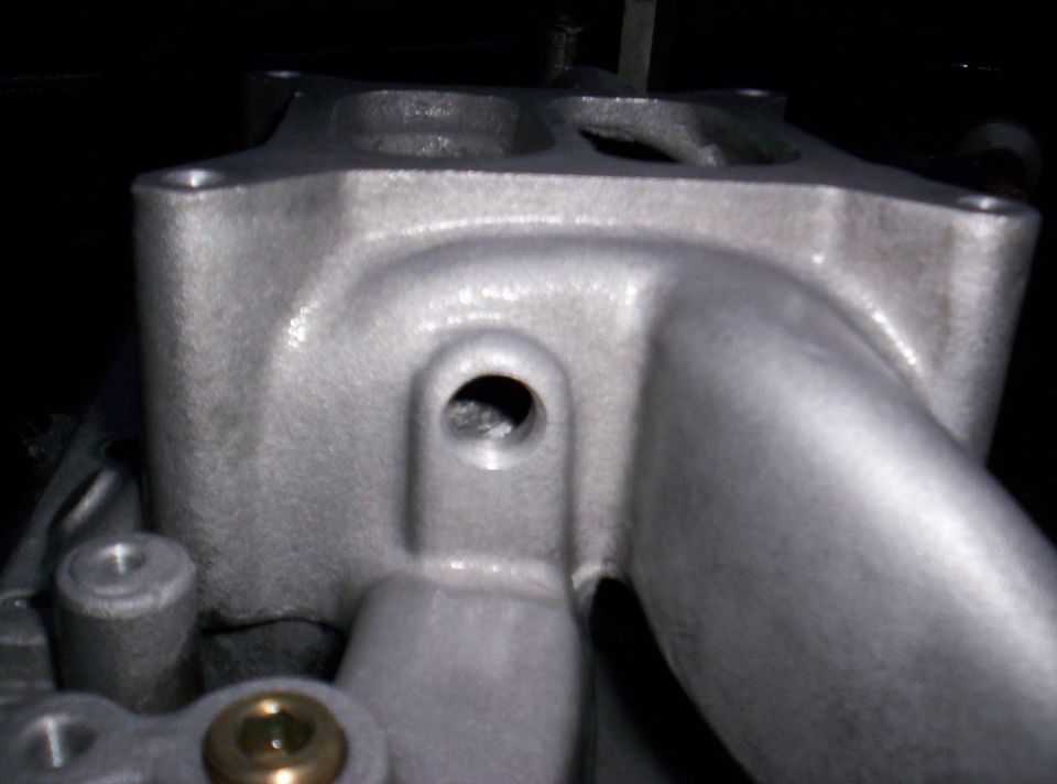 Aluminum intake manifold with bolt holes and a central opening