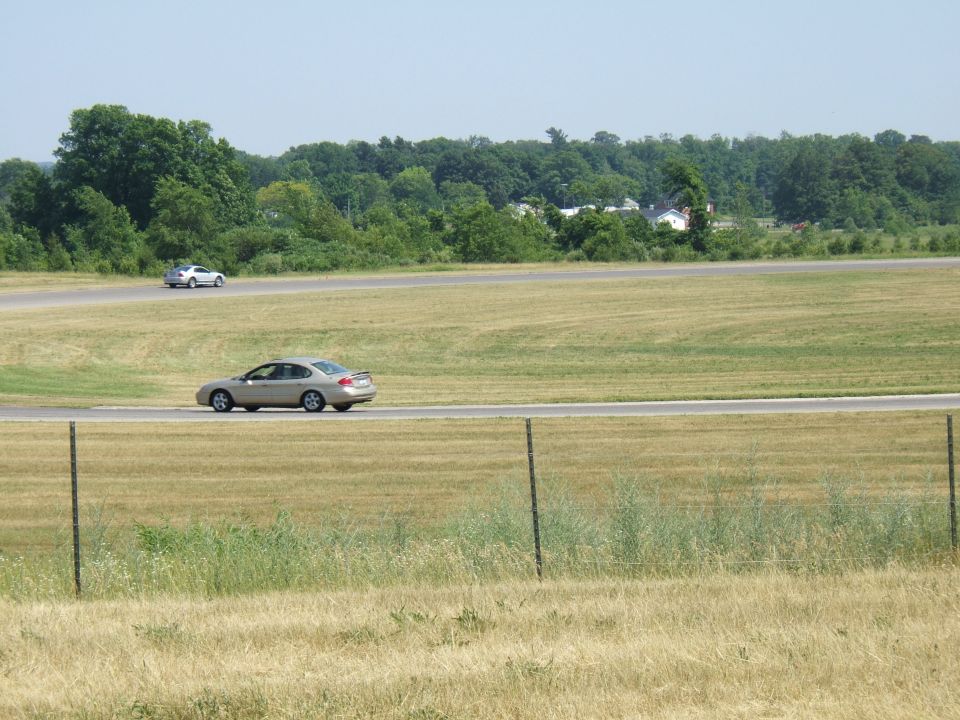 1998 Ford Taurus and another sedan on a racetrack, side view