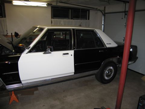 1991 Ford LTD Crown Victoria - Side view of a 1991 Ford Crown Victoria LTD police car in a garage.
