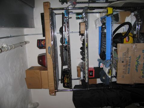 1991 Ford LTD Crown Victoria - Shelving unit holding various tools, boxes, and what appears to be automotive parts.