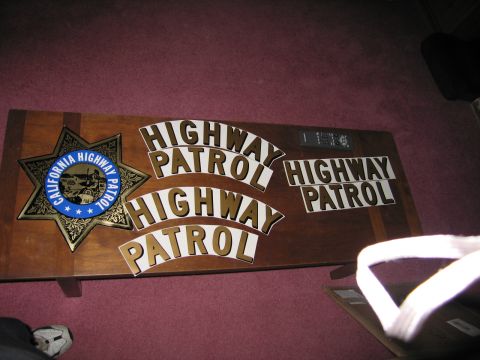 1991 Ford LTD Crown Victoria - A collection of California Highway Patrol insignia and lettering is displayed on a wooden surface.
