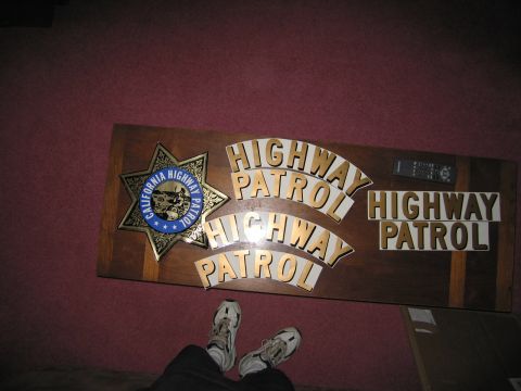 1991 Ford LTD Crown Victoria - A wooden plaque displays the California Highway Patrol emblem and lettering, along with a remote control.