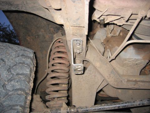 1991 Ford Explorer - Close-up of the rusty suspension and tire from underneath a vehicle.