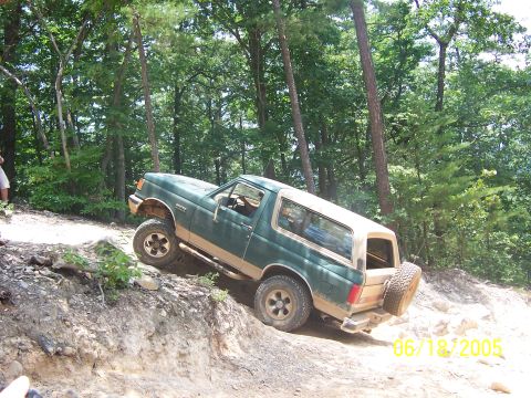 1978 Ford Bronco - A Ford Bronco navigates a challenging off-road trail on a sunny day.