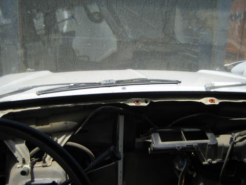 1990 Ford Bronco - Looking forward from inside a stripped vehicle at the cowl, single wiper and windshield with the dash partly removed.