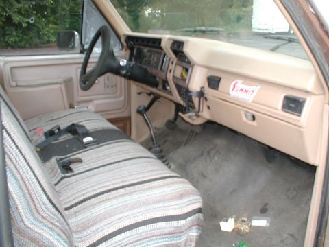 1979 Ford Bronco - Interior of a pickup truck, likely from the early 1980s, with a patterned seat cover and dashboard.