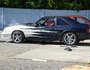 2002 Ford Mustang - A modified Ford Mustang is parked outdoors, showing custom paintwork and aftermarket wheels.