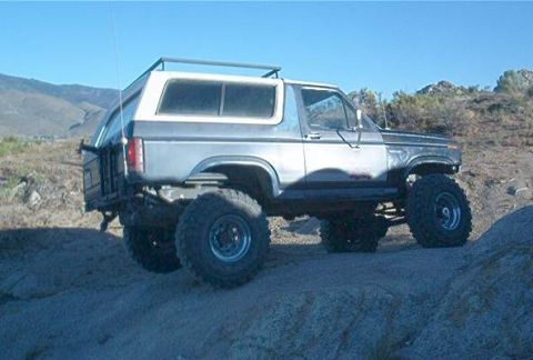 1986 Ford Bronco - This lifted 1980s Ford Bronco features a two-tone paint scheme and aggressive off-road tires, ready for terrain.