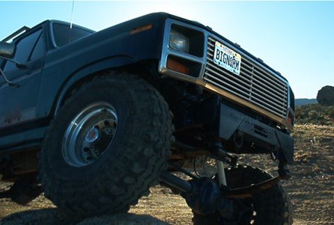 1986 Ford Bronco - This lifted truck features a prominent chrome grille and a custom license plate reading 'BIGNORM'.