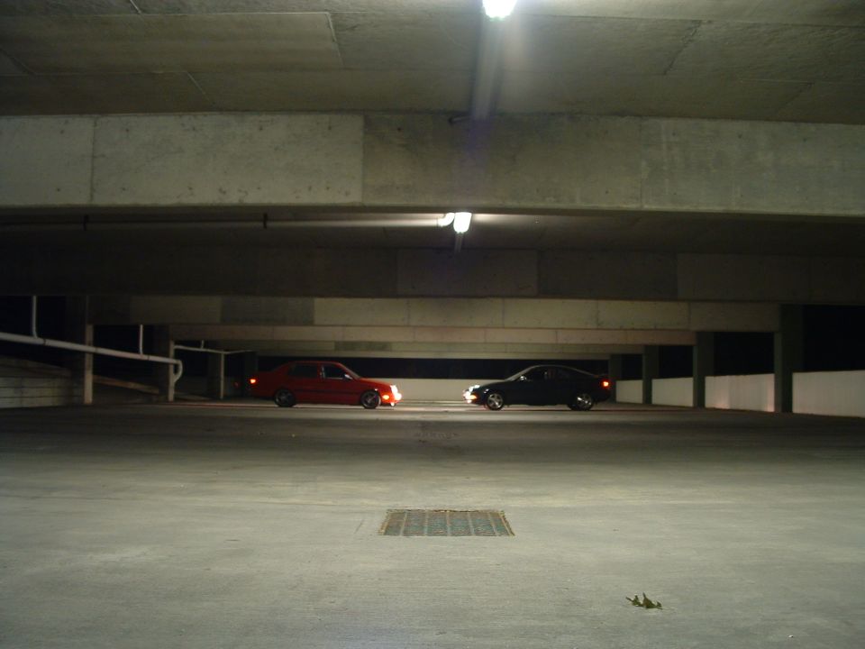Two cars parked in a dimly lit parking garage