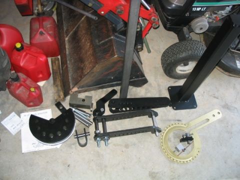1986 Ford F-150 - Various tools and equipment are laid out on a concrete floor, including red gas cans and metal fabrication tools.