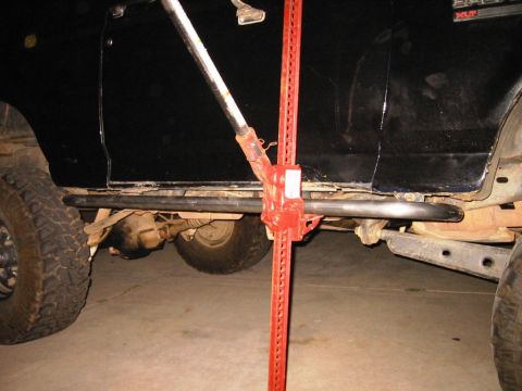1985 Ford Bronco - Hi-lift jack is used to lift the frame of a 1985 Ford Bronco for off-road modification.