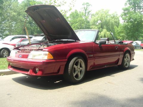 1993 Ford Taurus - A red 1993 Ford Mustang convertible is shown with its hood open, revealing the engine compartment.