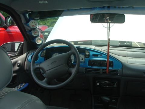 1993 Ford Taurus - Interior view of a 1993 Ford Taurus, aftermarket gauges and a glimpse of a red truck.
