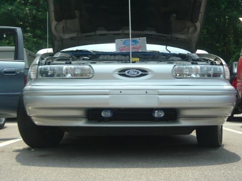 1993 Ford Taurus - Front view of a silver 1992 Ford Taurus, hood open, parked next to another vehicle.