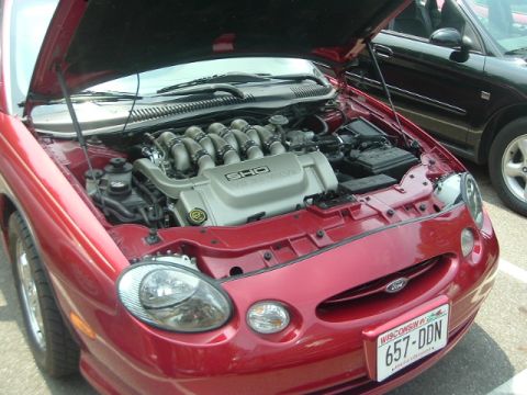 1993 Ford Taurus - Red 1996 Ford Taurus SHO engine bay detail, with another vehicle visible in the background.