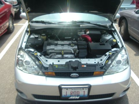 1993 Ford Taurus - Silver Ford Focus with hood open, revealing the engine compartment. The vehicle is parked outdoors.