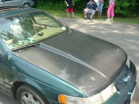 1993 Ford Taurus - This 1993 Ford Taurus features a custom carbon fiber hood with a prominent scoop.