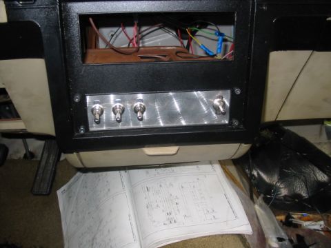 1985 Ford LTD Crown Victoria - A close-up view of a custom-installed switch panel and wiring in a vehicle's interior, with a manual on the floor.