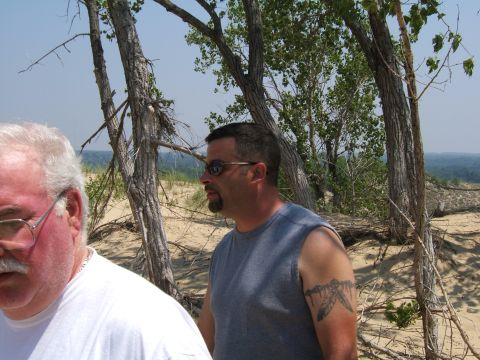 1998 Ford Taurus - Two men are pictured outdoors in a sandy environment with trees and a distant landscape visible.