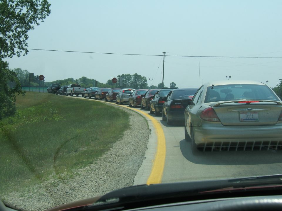 Gold sedan with distinctive grille, seen from rear in traffic