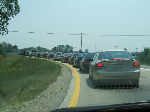 1998 Ford Taurus - A long line of cars are stuck in traffic on a sunny day.