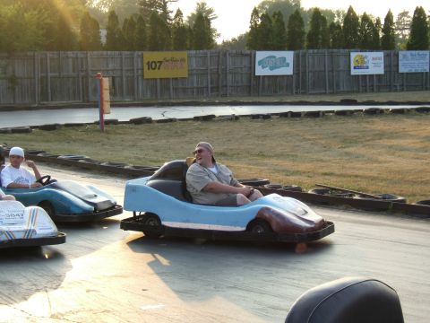 1998 Ford Taurus - People enjoying a sunny day racing go-karts on an outdoor track.