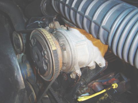 1986 Ford Bronco - Engine belt tensioner and pulley assembly with visible text on the belt.