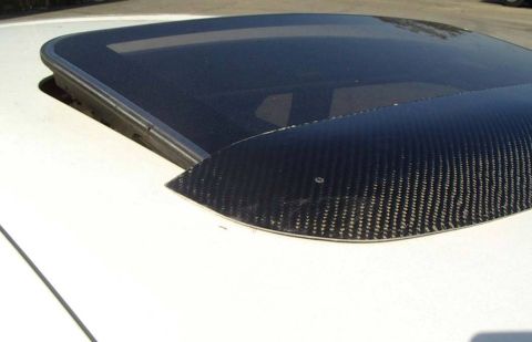 1993 Ford Taurus - Close-up of a sunroof with aftermarket carbon fiber trim on a white vehicle.