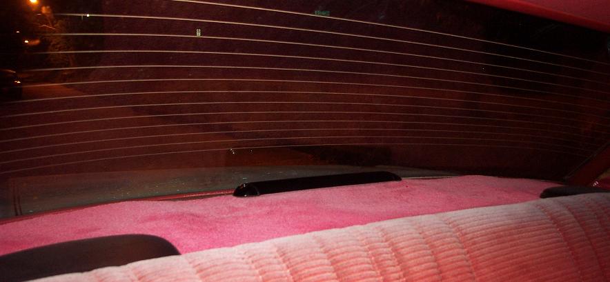 Red velour rear seat and defrosted rear window of a 1985 Ford Crown Victoria LTD