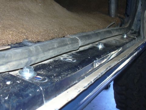 1991 Ford Bronco - Close-up view of bolts securing a rock slider to the interior of a blue vehicle.