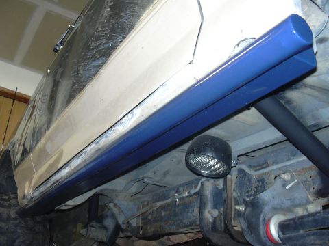 1991 Ford Bronco - Vehicle underside with newly installed blue rock sliders and a black light.