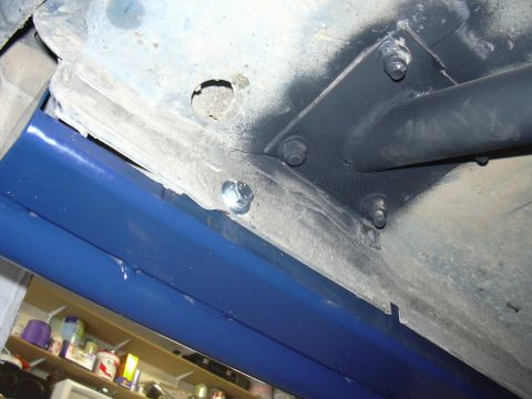 1991 Ford Bronco - Close-up view of blue rock sliders attached to the underside of a vehicle.