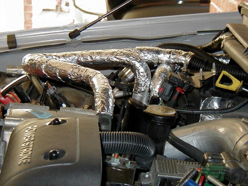 Diesel engine bay with foil-wrapped hoses and Power Stroke cover