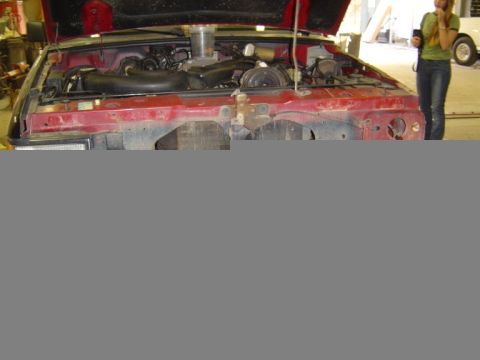 1989 Ford Ranger - Engine bay of a red 1989 Ford Ranger, viewed from the front with the hood raised.