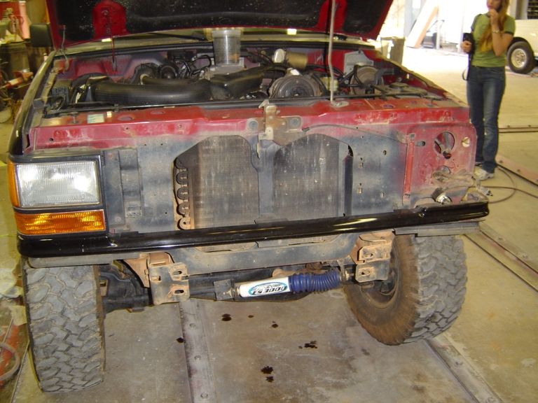 1989 Ford Ranger front end, hood open, showing engine and radiator. Aftermarket blue shock absorber visible