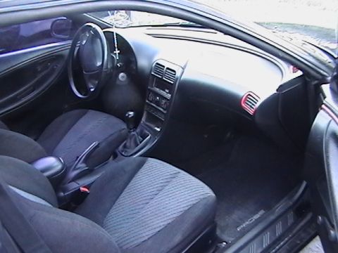 1993 Ford Probe - The interior of the car shows the dashboard, steering wheel, and front seats.