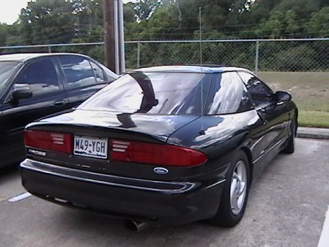 1993 Ford Probe - The rear of a black 1993 Ford Probe is visible, parked in a lot.