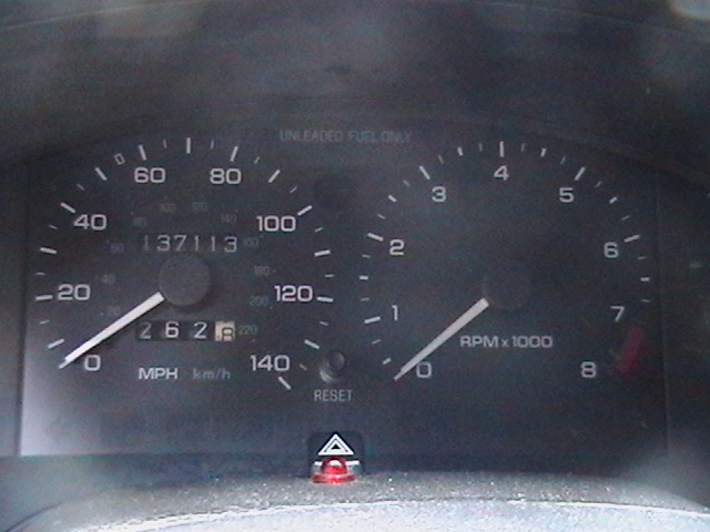 Close-up of a car's speedometer and tachometer. Speedometer reads 0 MPH, odometer shows 137113 miles. Tachometer reads 0 RPM x 1000