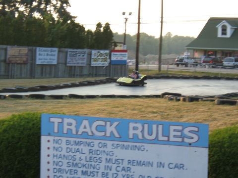 1998 Ford Taurus - A go-kart navigates a track, with a sign detailing track rules visible in the foreground.
