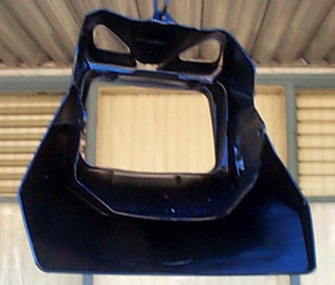 Dark blue motorcycle headlight fairing hanging, showing its headlight openings