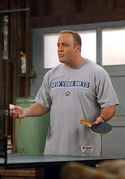 1998 Ford Taurus - A man stands in a garage holding a ping pong paddle and ball, ready to play.