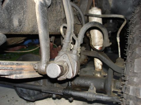 1978 Ford F-250 - Close-up view of a vehicle's power steering system, showing hydraulic lines and mechanical components.