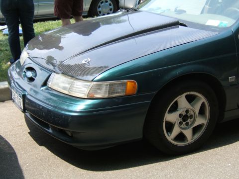 1998 Ford Taurus - This 1998 Ford Taurus shows a carbon fiber hood and aftermarket wheels.