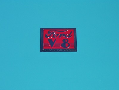 1995 Ford Bronco - A red and blue Ford V8 emblem is shown against a solid blue background.