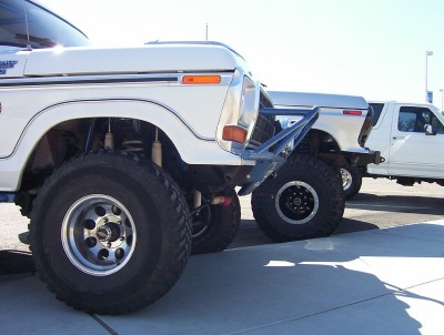 1995 Ford Bronco - This 1978 Ford Bronco features a custom front bumper and oversized tires, parked alongside other vehicles.